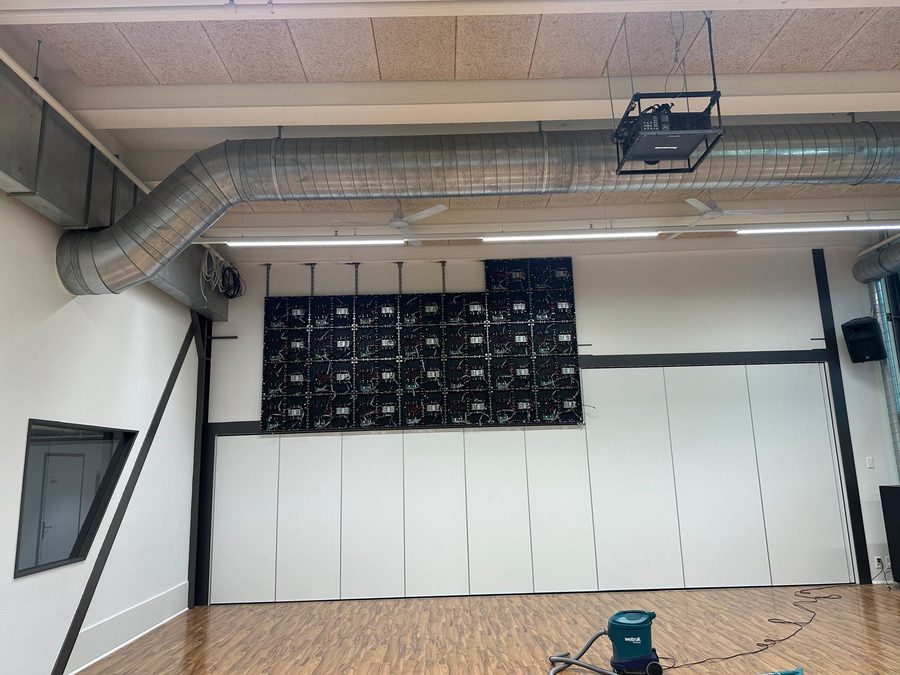 Nahezu vollständig montierte LED-Wand aus Cabinets ohne LED-Module, darüber der bisherige Beamer