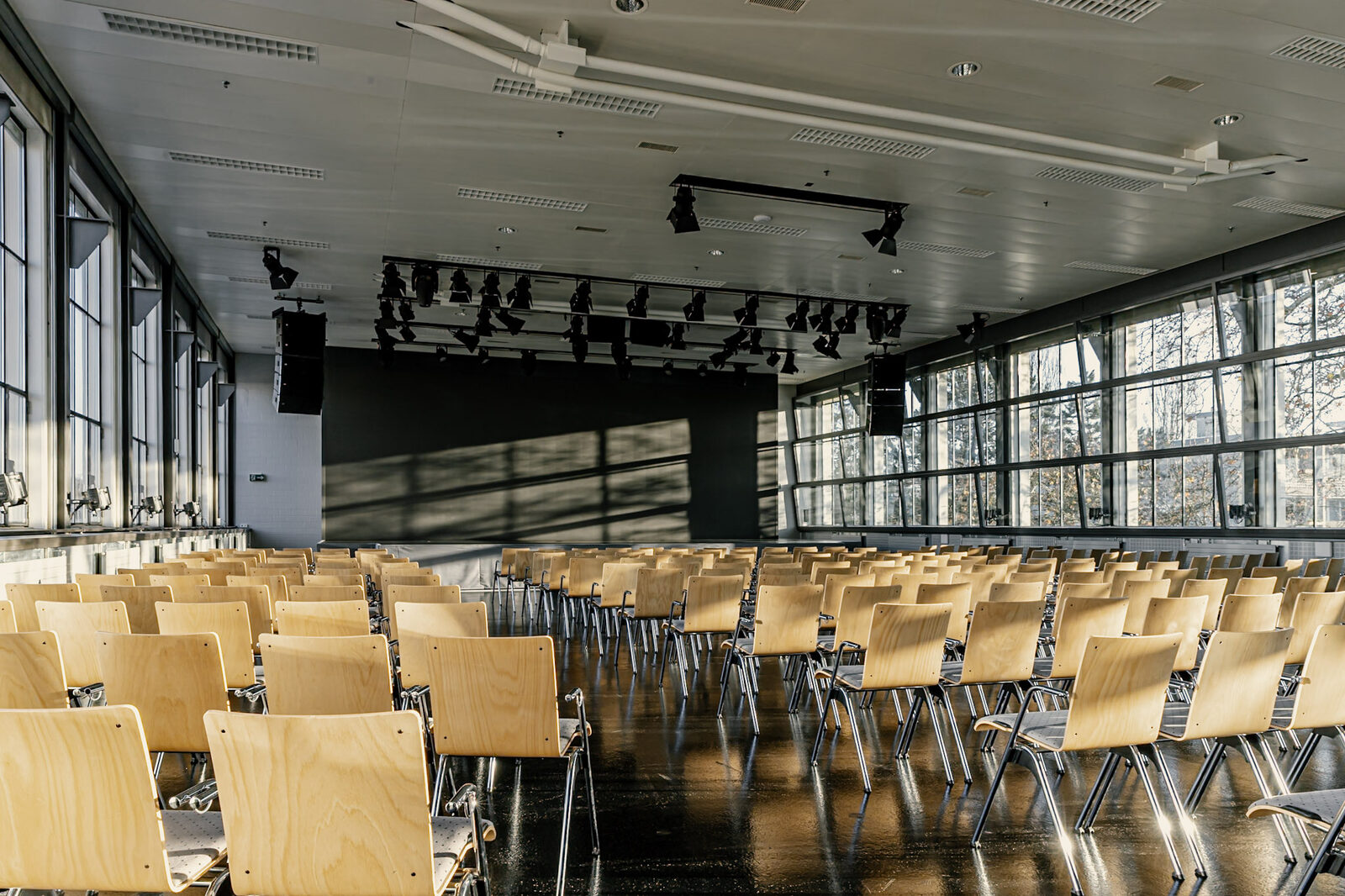 Plenarsaal der Eventfabrik Bern mit Bestuhlung und Bühnenwand